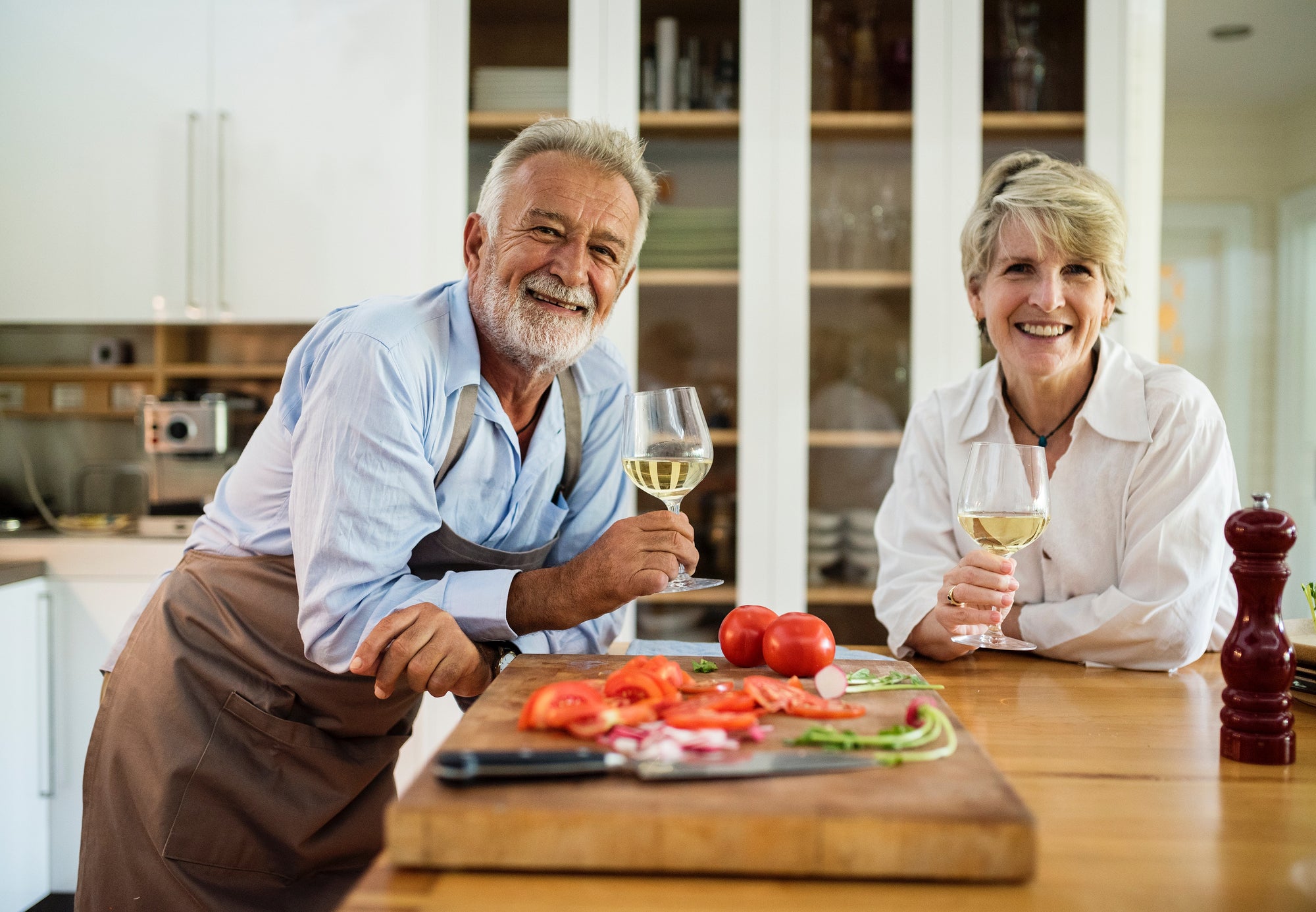 Elderly couple with a glass of wine enjoying healthy Mediterranean appetizers